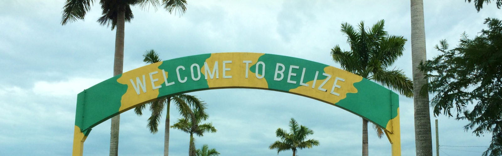 An archway sign reads "Welcome to Belize".